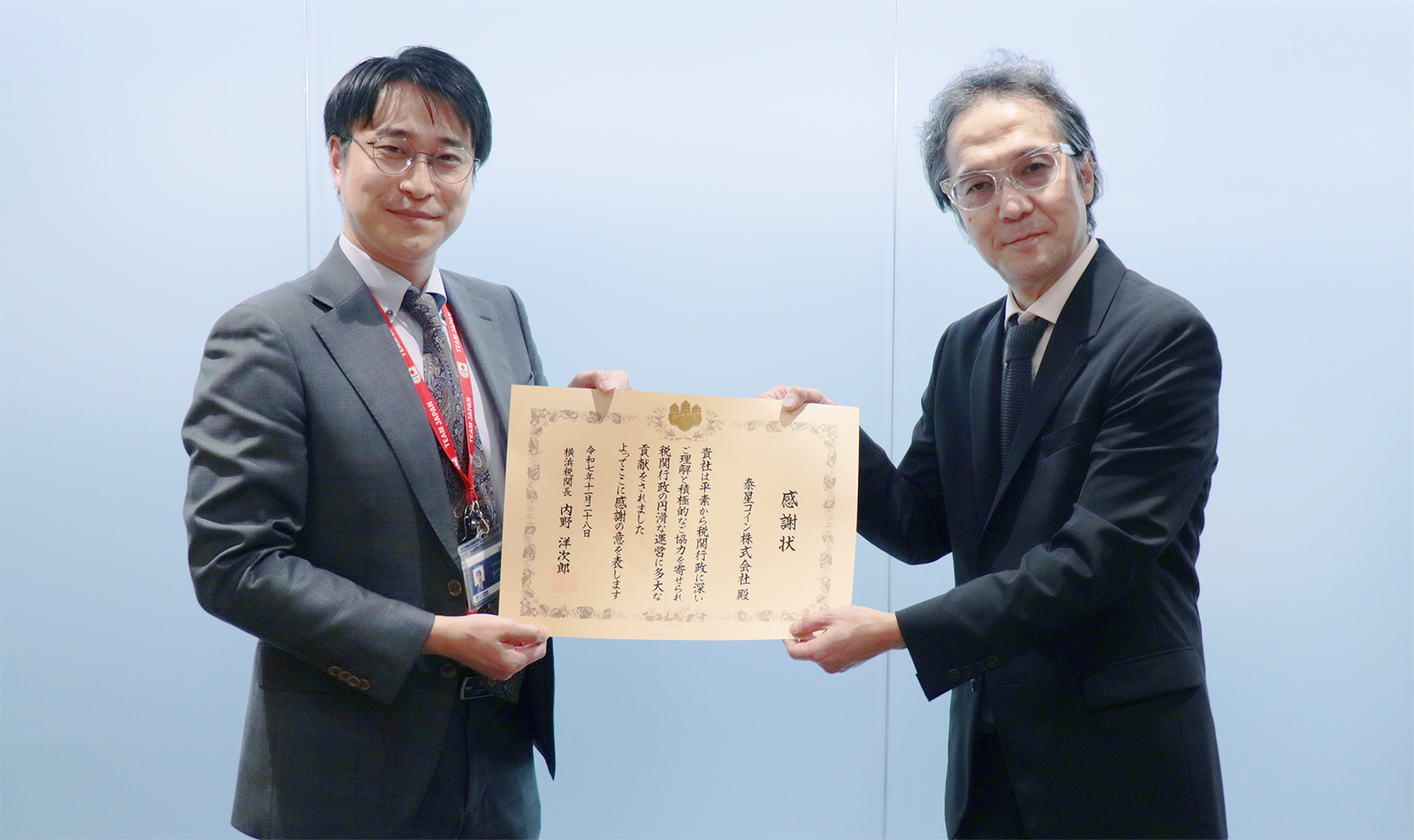 横浜税関より感謝状を受け取る泰星コインの佐々木伸淳社長（左）
